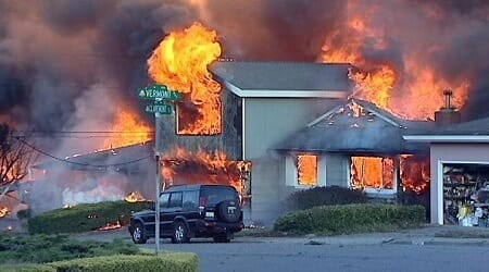 Photo of two-story house gulfed in flames