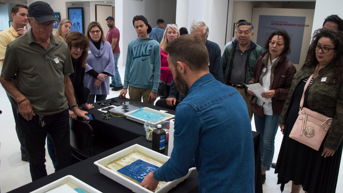 Picture of Sullivan Solar Power team along with MOPA patrons developing cyanotype images